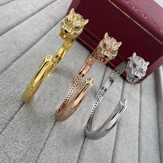 Cartier open-style cuff bracelet featuring a diamond-set panther head and spotted motif.